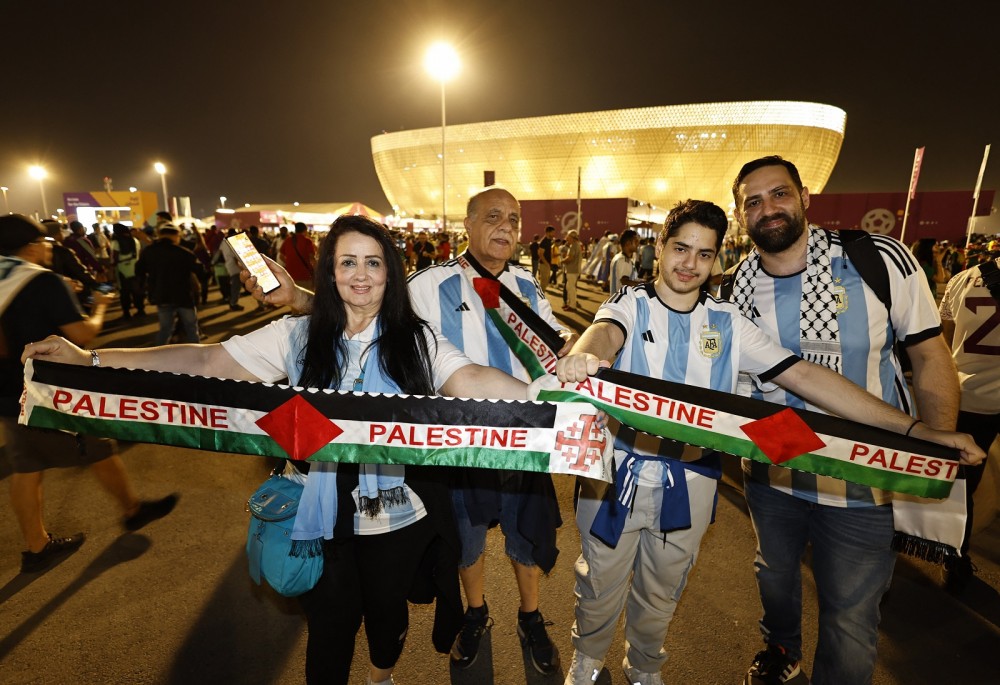مشجعو المونديال وهم يحملون وشاح فلسطين