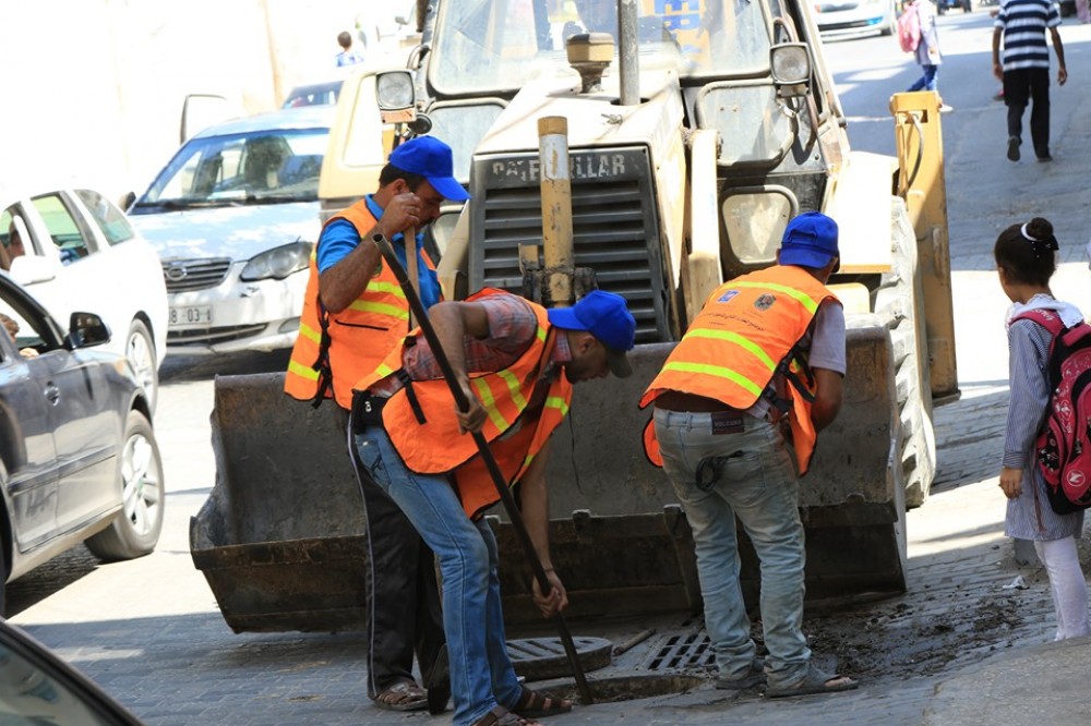طواقم بلدية غزة خلال تنظيف مصارف المياه