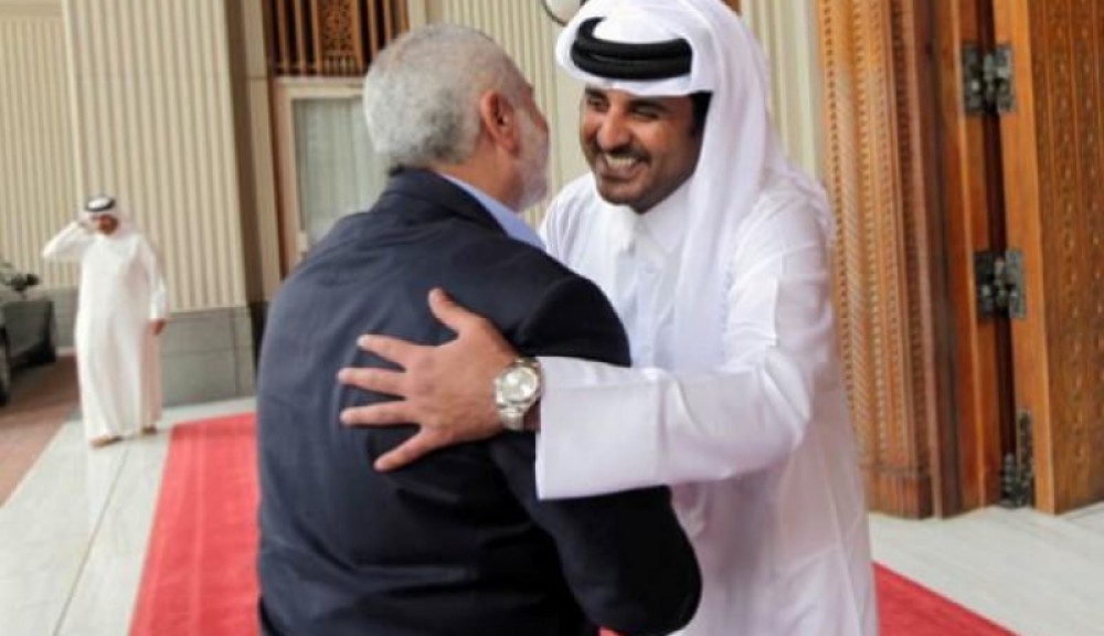 أرشيف - أمير قطر يعانق إسماعيل هنية