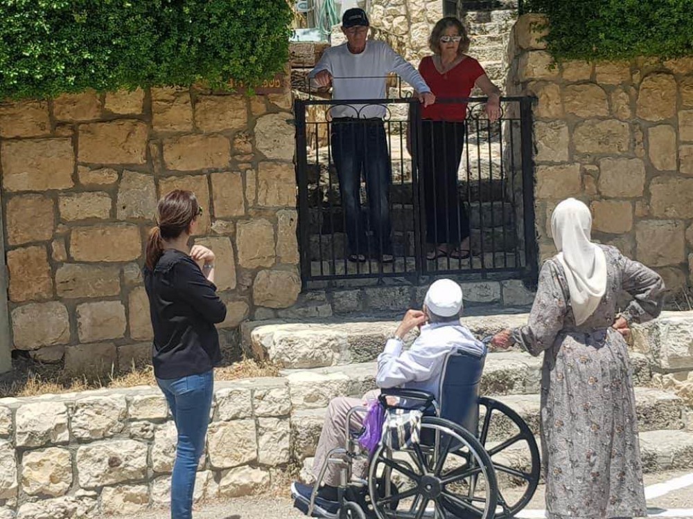 عائلة فلسطينية تقف أمام منزلها الذي استولى عليه مستوطنون إسرائيليون
