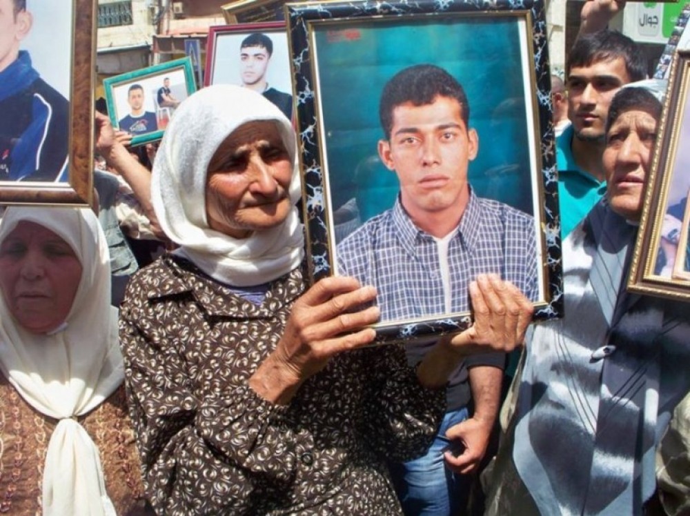 والدة الشهيد حمدوني خلال رفعها صورته