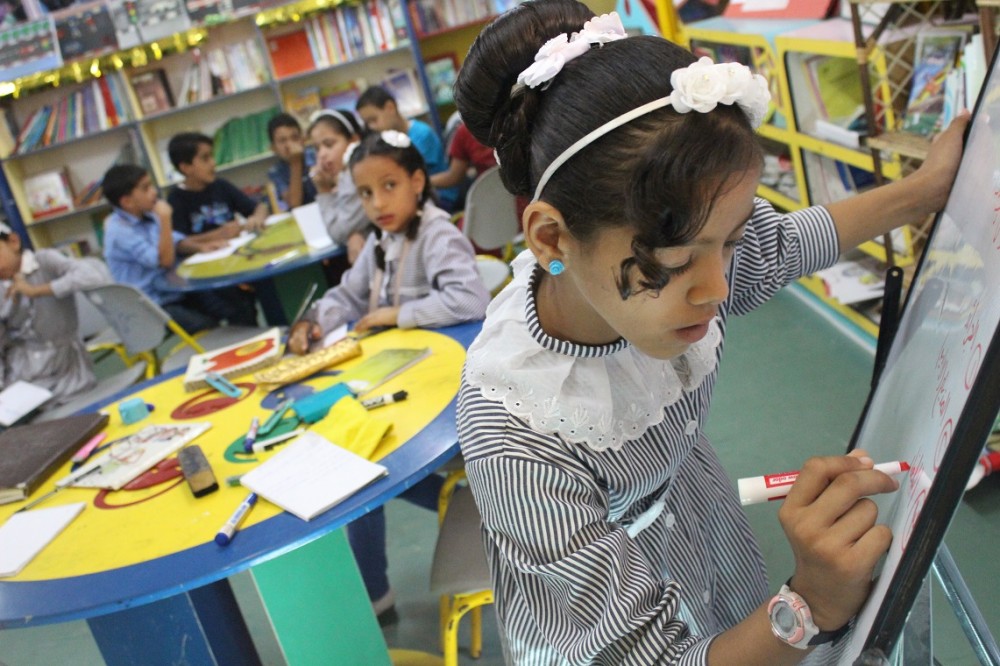 طالبة  تكتب على السبورة