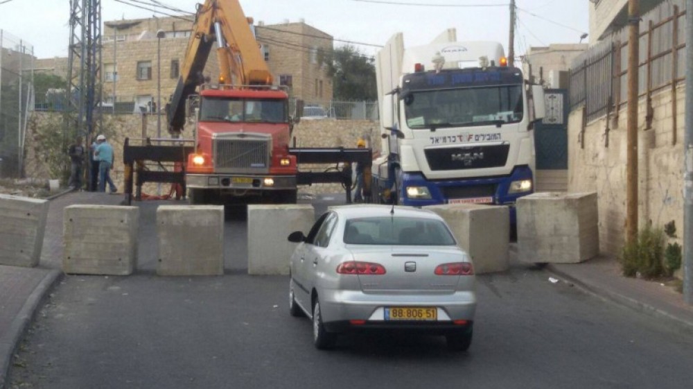 شاحنات تقوم بانزال مكعبات اسمنتية لبناء الجدار