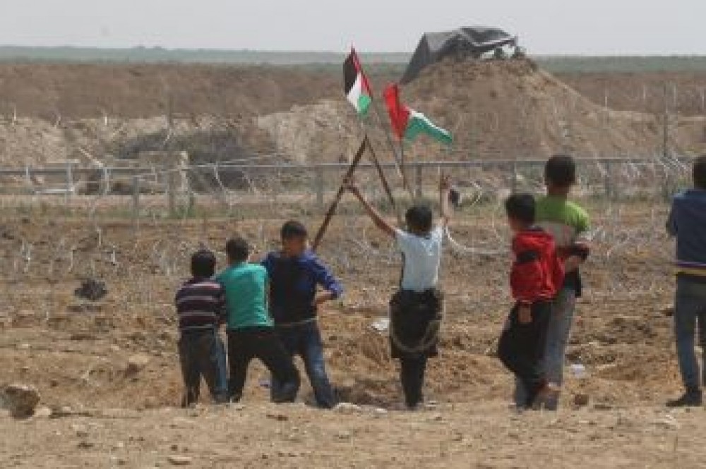 اطفال يرفعون علم فلسطين  خلال مسيرة العودة