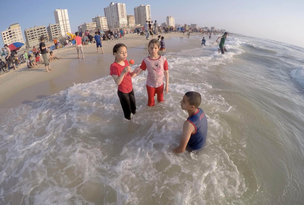 أطفال يسبحون على شاطئ البحر