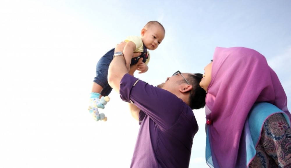 زوج يلعب مع طفله برفقة زوجته