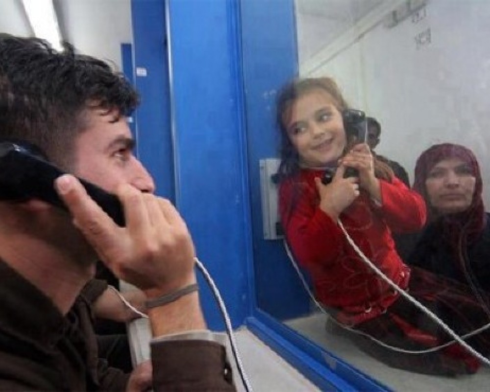 لحظة لقاء أسير مع ابنته خلال زيارتها له 