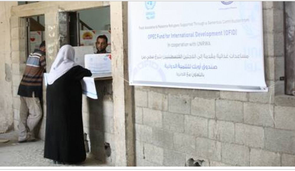 لاجئون فلسطينيون يتسلمون المعونة الغذائية من مركز توزيع 
