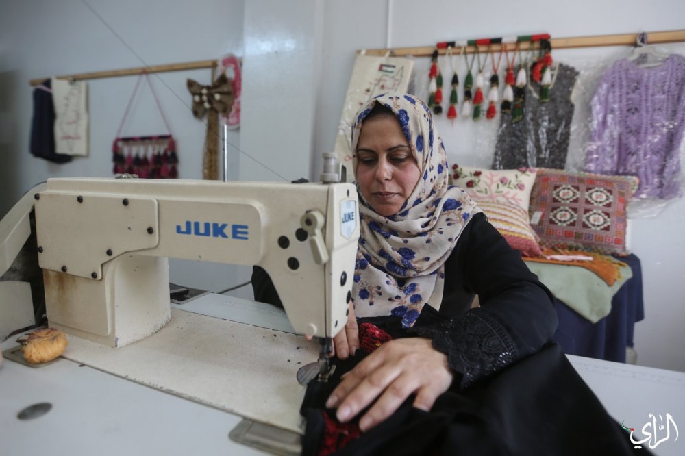 الخياطة شيرين مهنا، خلال عملها بمركز تمكين المرأة والمجتمع بغزة.