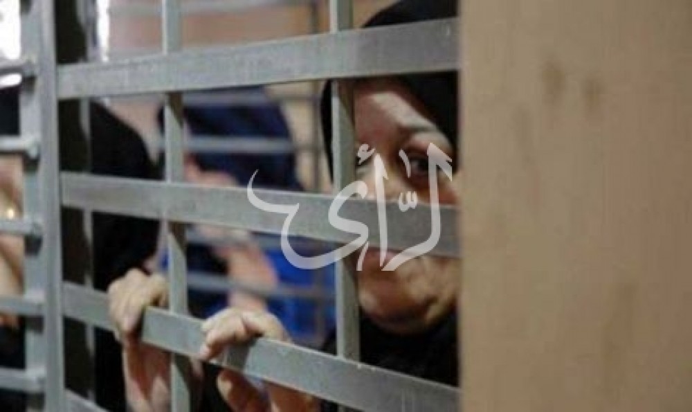 اسيرة تنظر من خلف قضبان الاحتلال- صورة من الارشيف