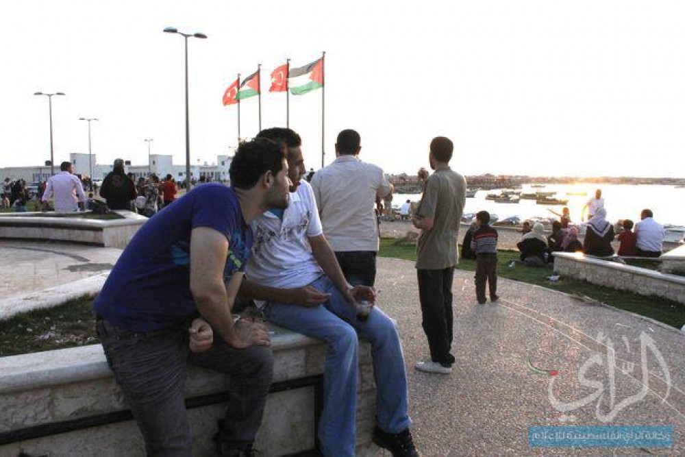شباب يجلسون قرب لسان الميناء