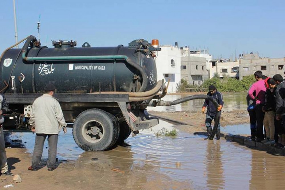 طواقم بلدية غزة أثناء شفط مياه الأمطار بشارع النفق