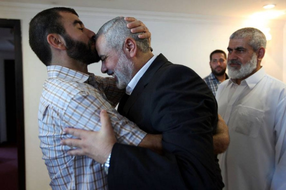 رئيس الوزراء أثناء تهنئته لأحد الأسرى المحررين