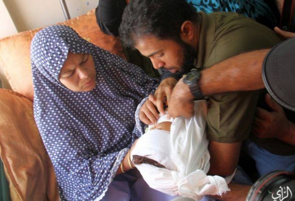 والدي الطفل مؤيد خلال إلقاء نظرة الوداع عليه
