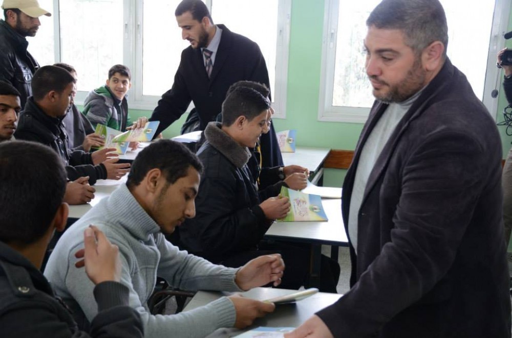 جانب من توزيع الكراسة على الطلبة 