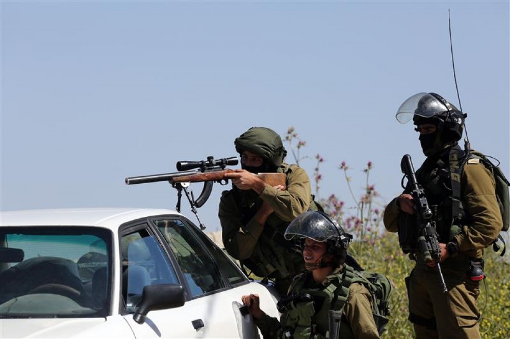 جندي اسرائيلي يصوّب بندقيته باتجاه فلسطينيين بالضفة 